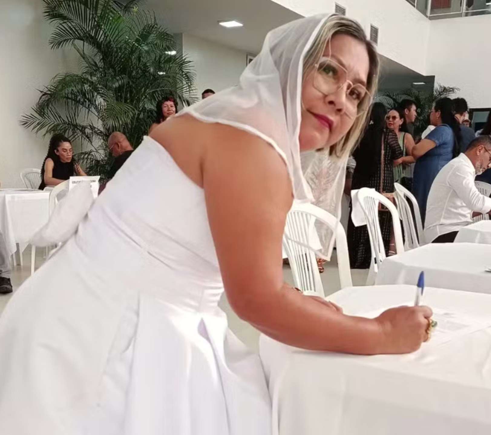 Pedagoga Nayra Saldanha, de 50 anos, assina termo de posse vestida de noiva