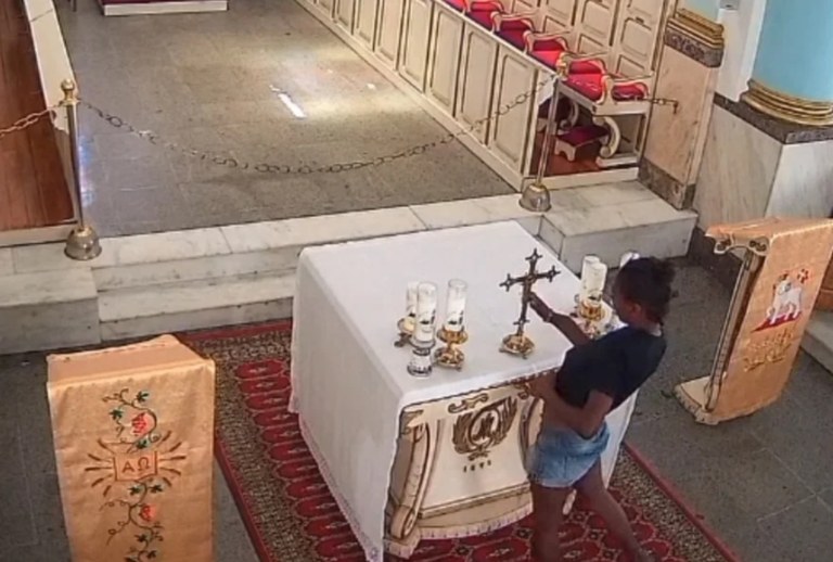 Câmeras de segurança da igreja, localizada em Niterói, registraram o momento em que a mulher pega o crucifixo e o esconde embaixo da blusa