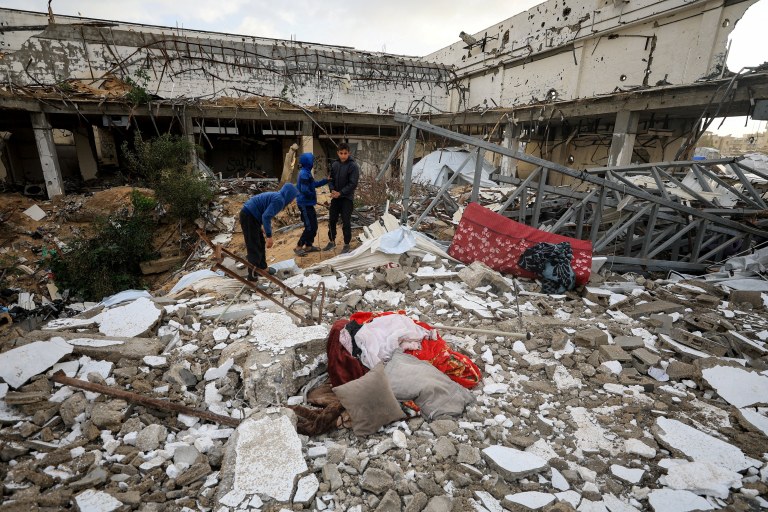 Palestinos inspecionam danos causados em prédio atingido por ataque de Israel na Cidade de Gaza, em meio ao genocídio palestino - 13/01/2026