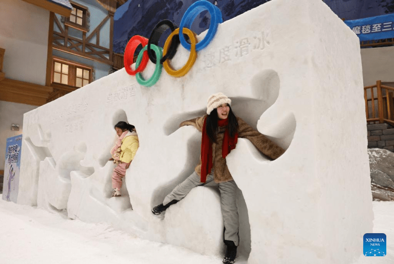 Turistas se divertem no parque temático coberto de gelo e neve em Shanghai
