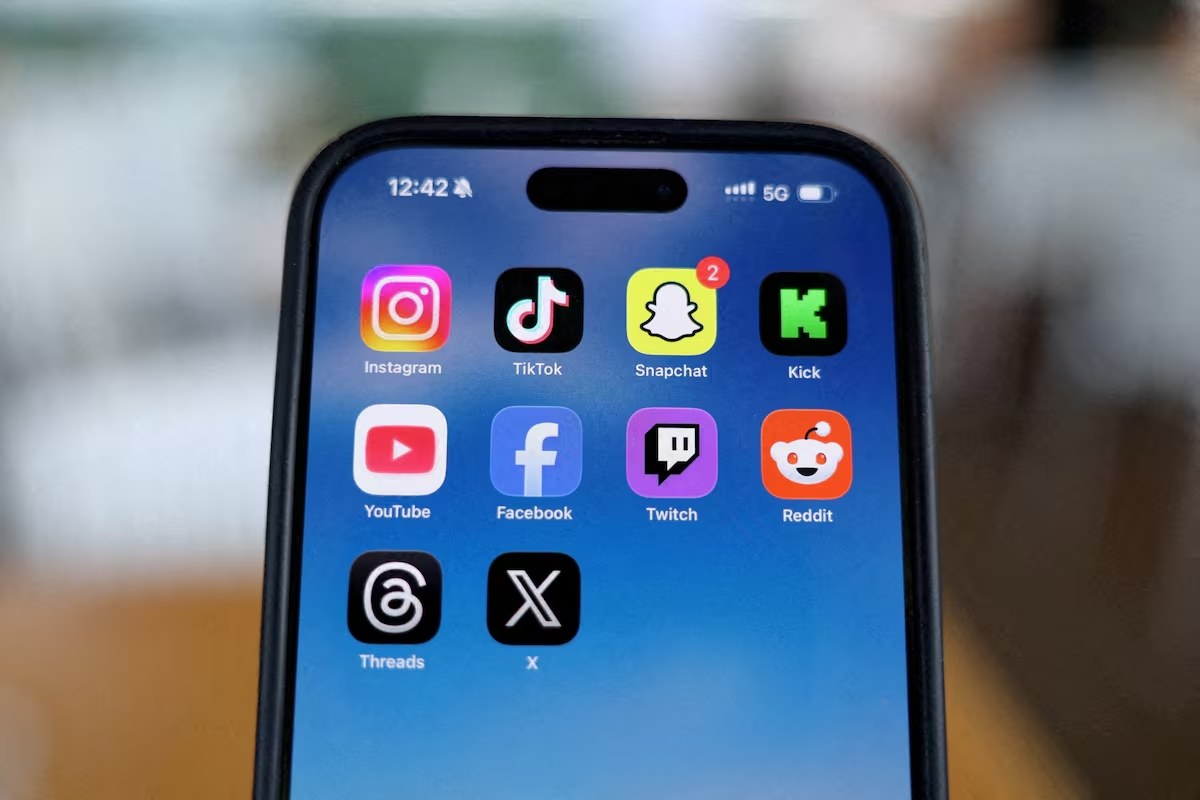 Instagram, TikTok, Snapchat, Kick, YouTube, Facebook, Twitch, Reddit, Threads e X estão exibidos em um celular nesta ilustração, feita em 9 de dezembro de 2025