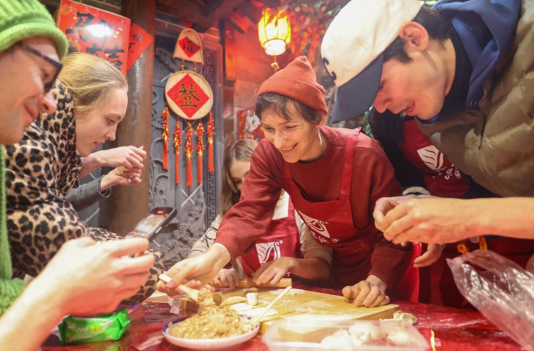 Turistas estrangeiros preparam bolinhos em um hotel em Sanmenxia, ​​na província de Henan, no centro da China
