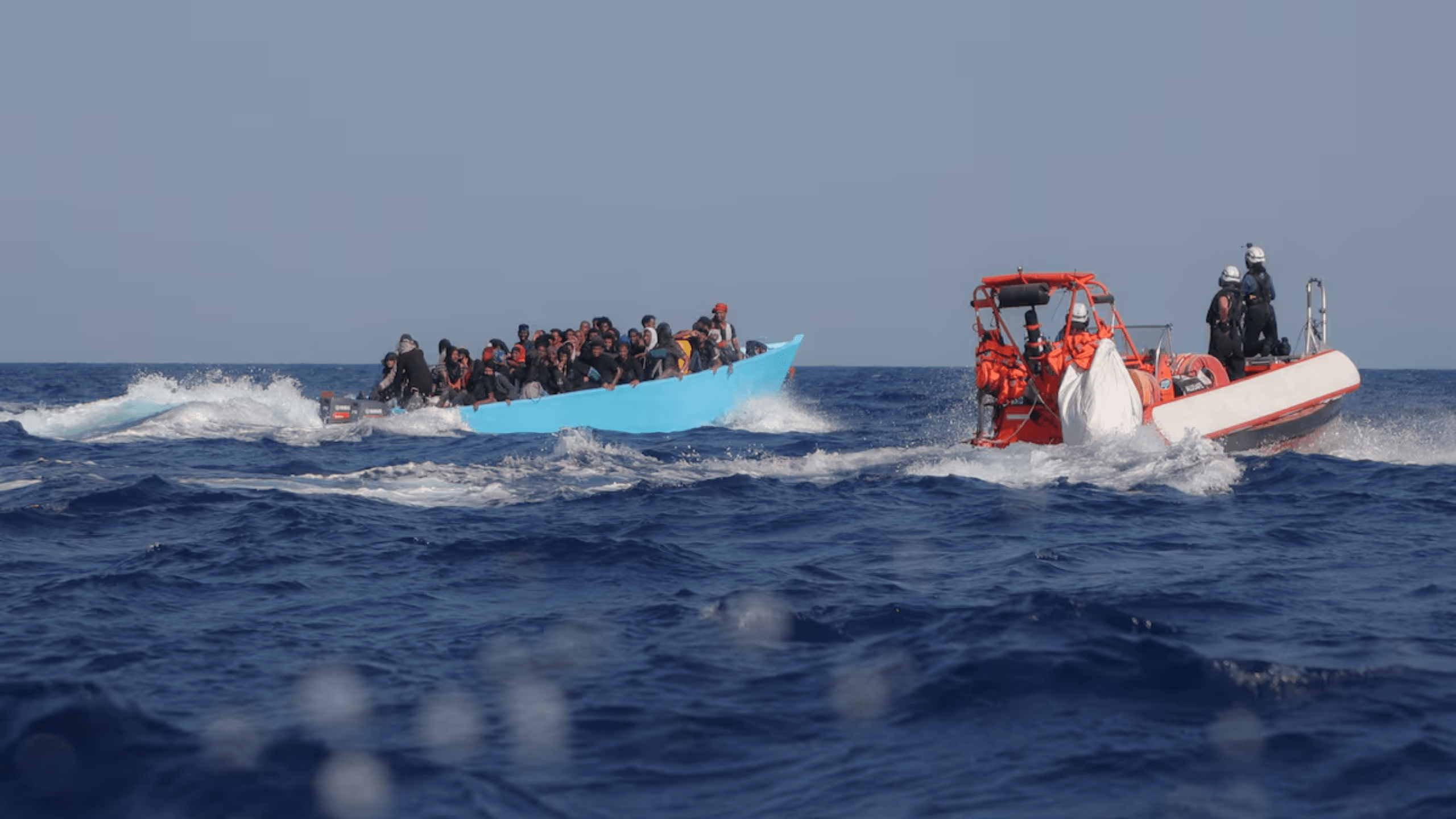 Migrantes a bordo de uma embarcação superlotada são abordados pela tripulação do navio de busca e resgate Sea-Watch 5, operado pela ONG alemã Sea-Watch