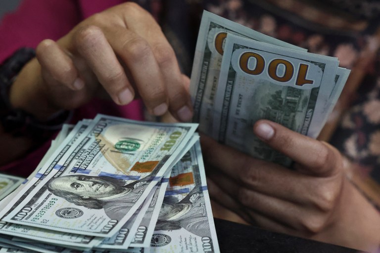 Pessoa conta notas de dólar em uma casa de câmbio em Jacarta, Indonésia, em 9 de abril de 2025.