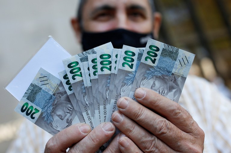 Um homem segura notas de 200 reais em Brasília