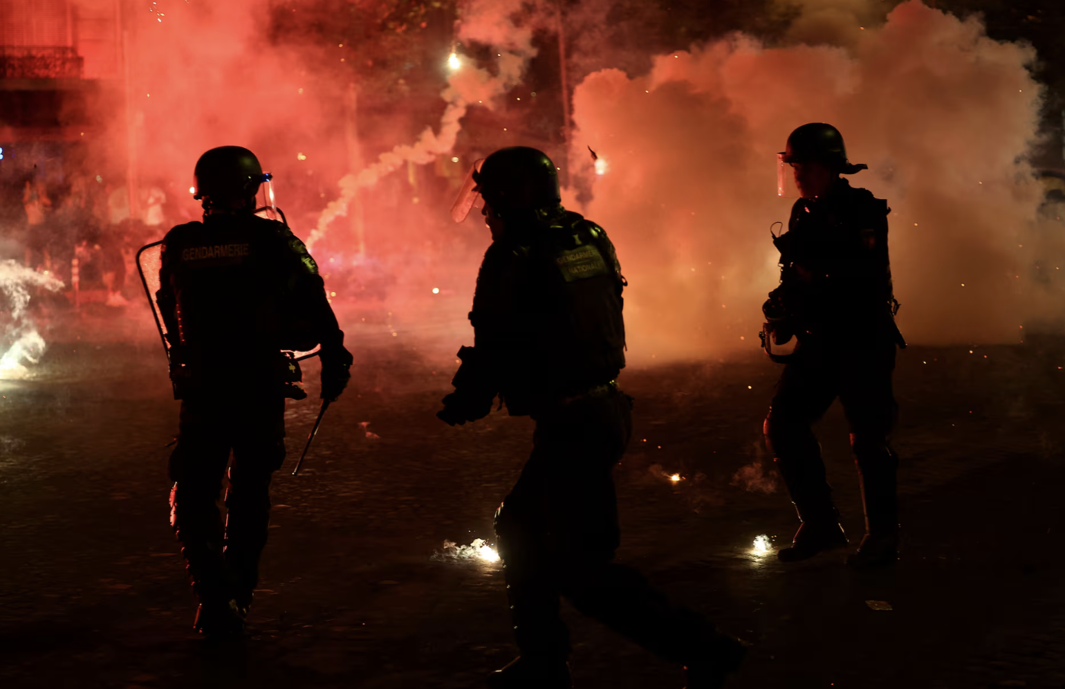 Policiais se protegem de sinalizadores após o Paris Saint-Germain vencer a Liga dos Campeões da UEFA