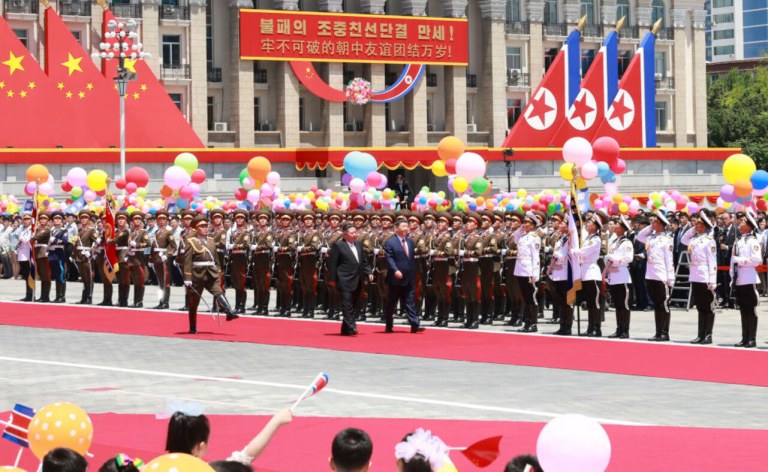 Kim Jong Un e Xi Jinping passam as tropas em revista