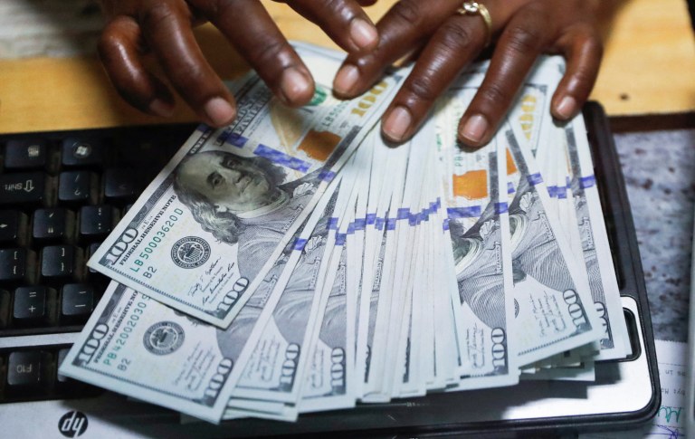 Pessoa separa notas de dólar americano em casa de câmbio no centro de Nairóbi, Quênia, em 16 de fevereiro de 2024