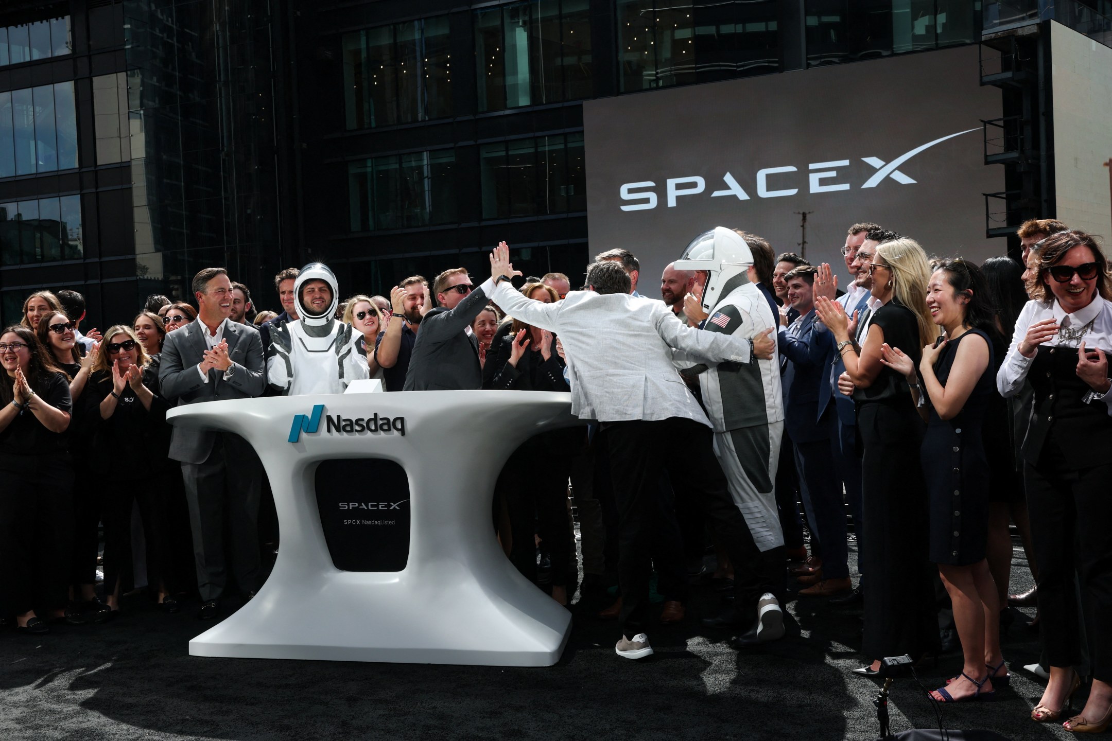 Membros da liderança da SpaceX e convidados comemoram IPO na Nasdaq.