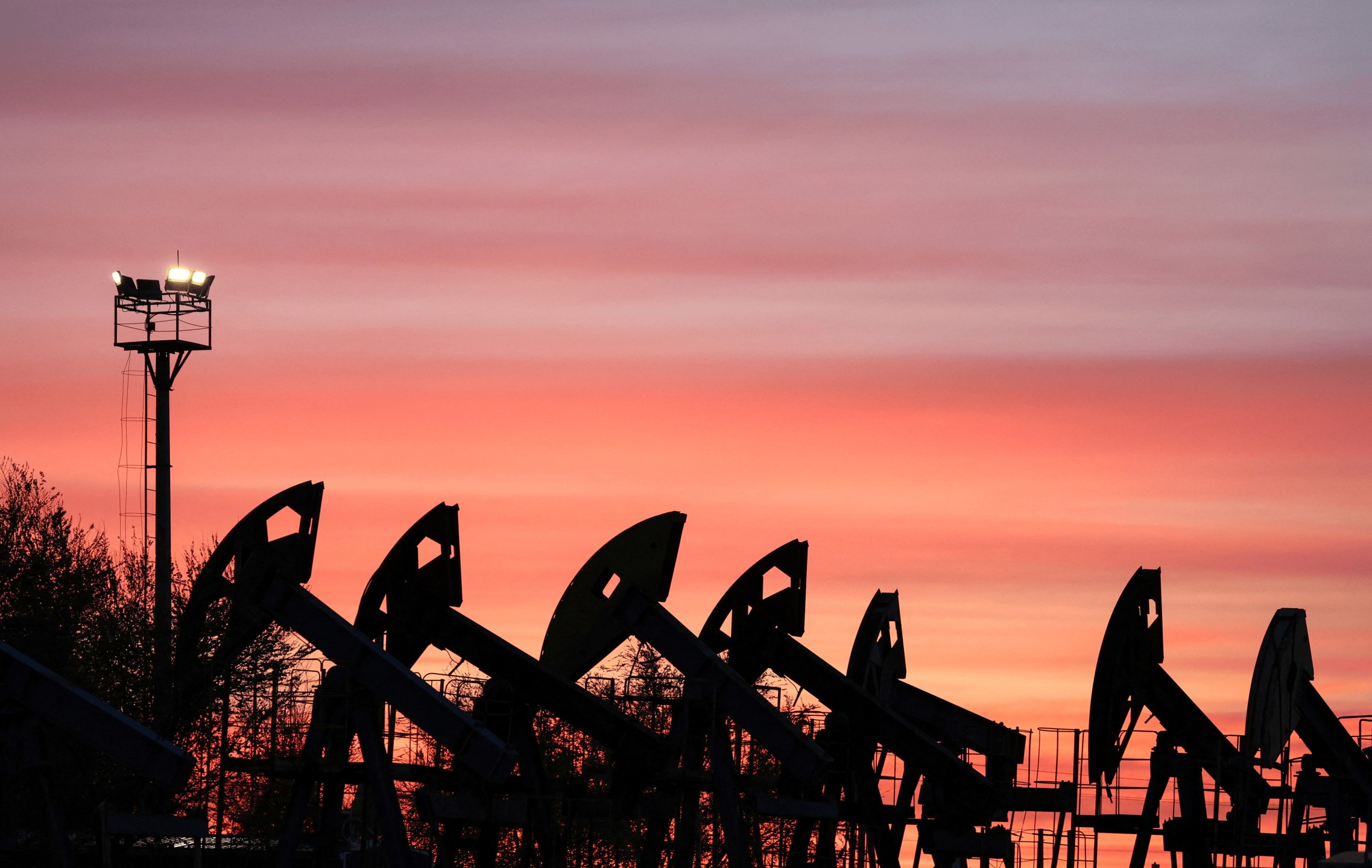 As nuvens do pôr do sol brilham sobre as bombas de extração no campo petrolífero de Airankol, operado pela Caspiy Neft na região de Atyrau, no Cazaquistão
