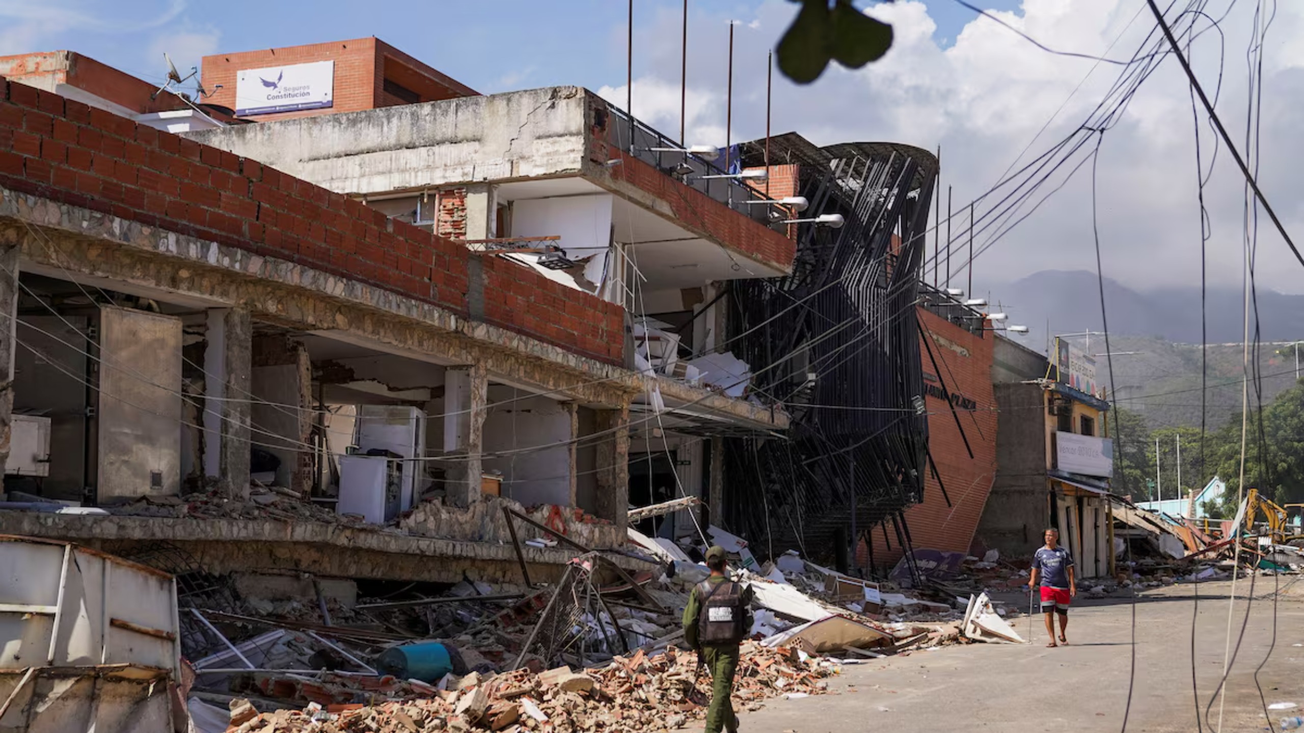 Um integrante da Força Armada Nacional Bolivariana caminha entre edifícios danificados uma semana após os terremotos que atingiram o país, em La Guaira, Venezuela