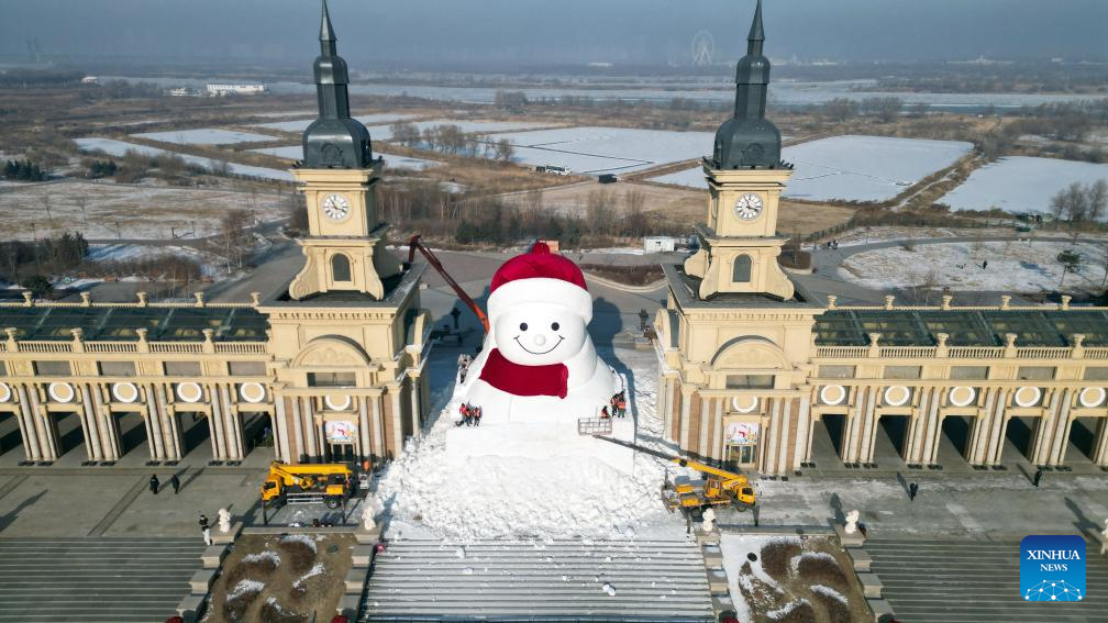 Escultores e trabalhadores constroem boneco de neve gigante em Harbin, na Província de Heilongjiang