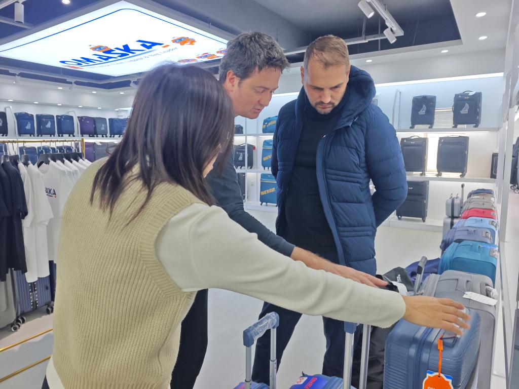 Empresário brasileiro Jhonnathan seleciona produtos em sala de exposições de uma empresa de malas e bolsas em Baigou, cidade de Baoding, na Província de Hebei, no norte da China. (Dong Xiaokun/Xinhua)