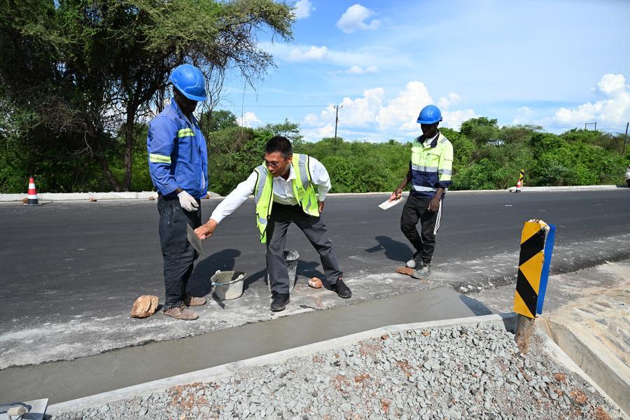 Foto tirada em 7 de dezembro de 2025 mostra trabalhadores da construção civil realizando a recuperação do pavimento no trecho Matambo-Marara da Estrada Nacional 301, na cidade de Tete, em Moçambique. (China Henan International Cooperation Group/Divulgação via Xinhua)